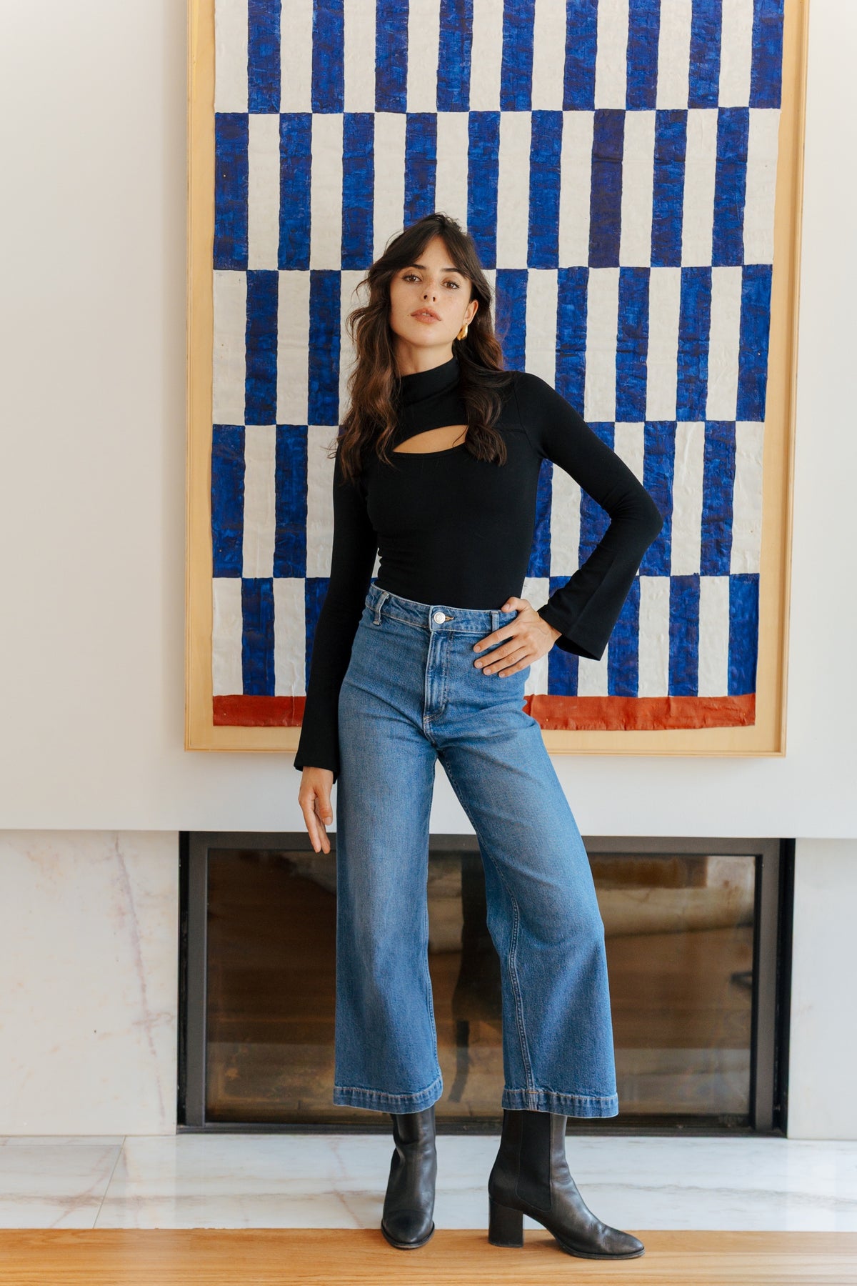Lou en body noir devant une œuvre bleue